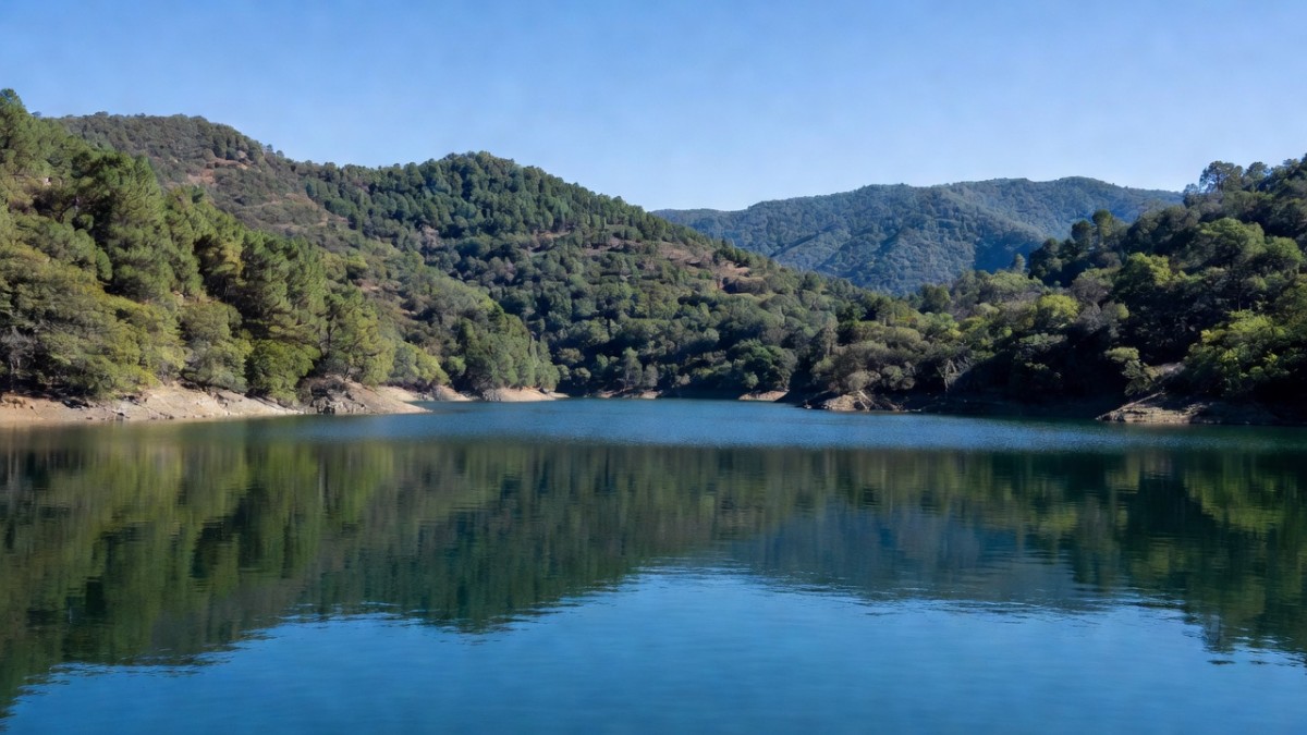 A Cutzamala system reservoir at high water level surrounded by forested hills