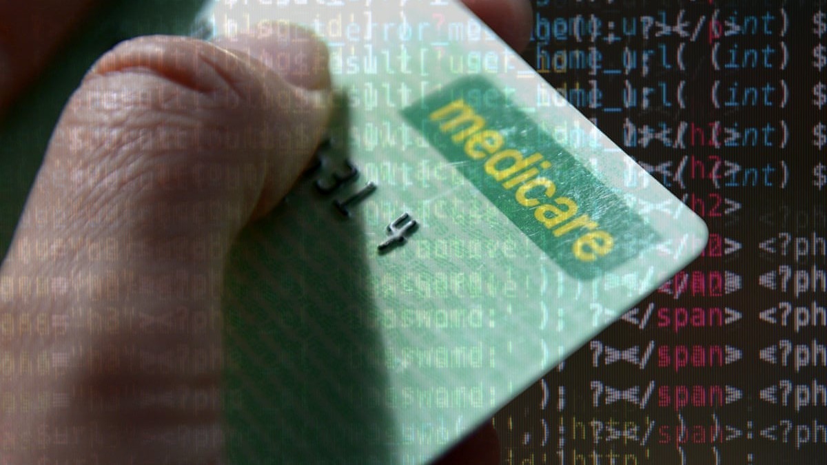 A Medicare card held in front of a screen of source code. Image: The Guardian