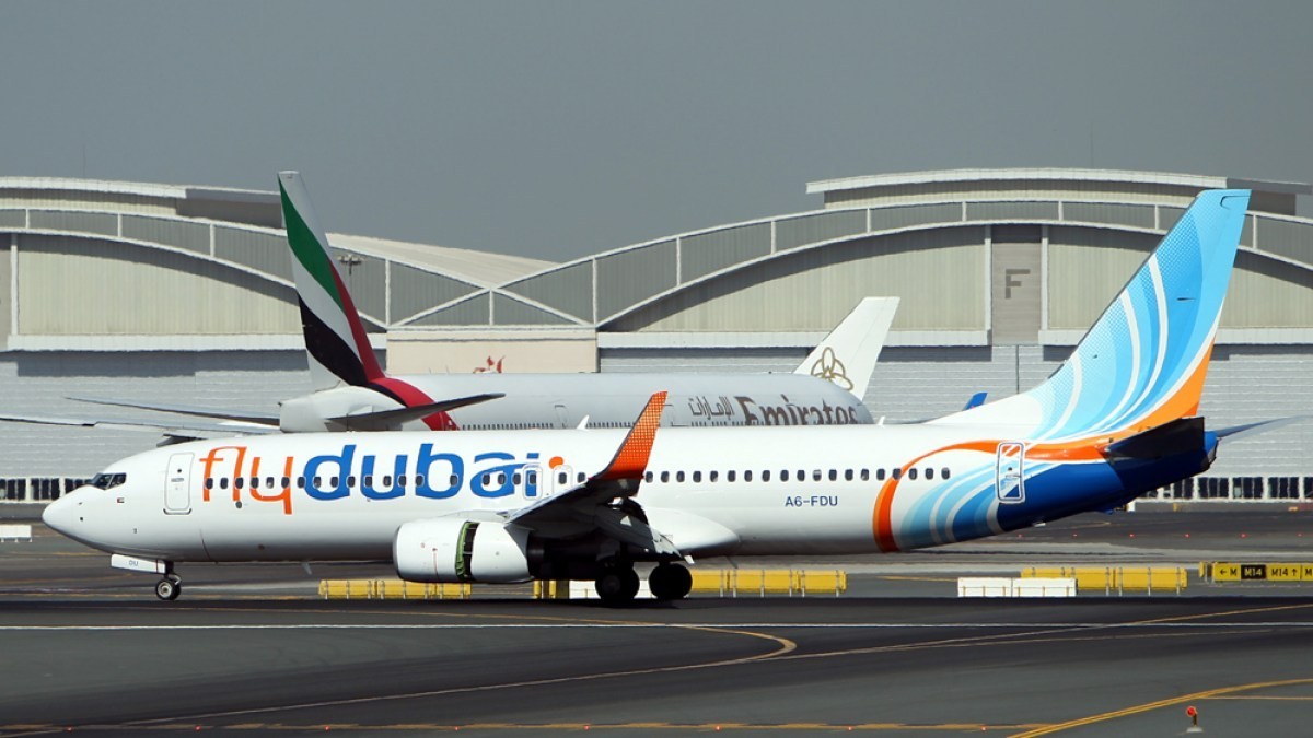 A flydubai Boeing 737 on an airport tarmac with an Emirates Airbus A380 parked behind it. File image