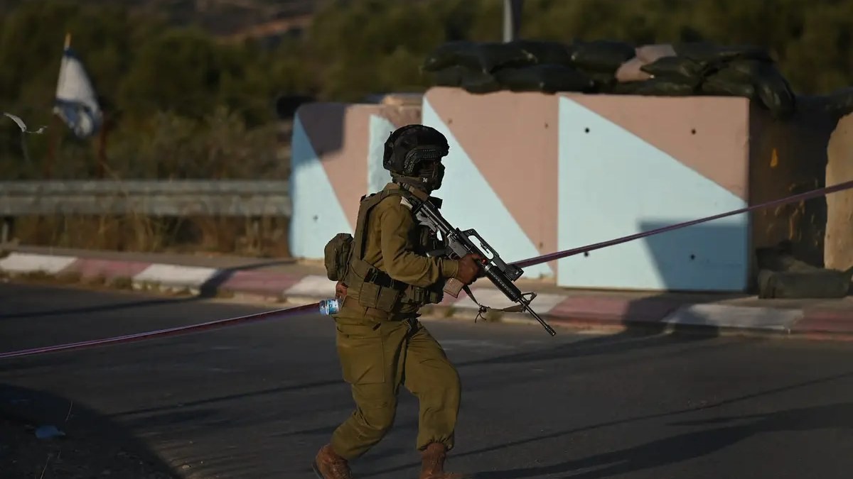 A member of the Israeli security forces runs past concrete barriers near a West Bank checkpoint after the Route 443 car-ramming attack, 23 September 2026. Photo: Yoav Dudkevitch/TPS via Israel National News