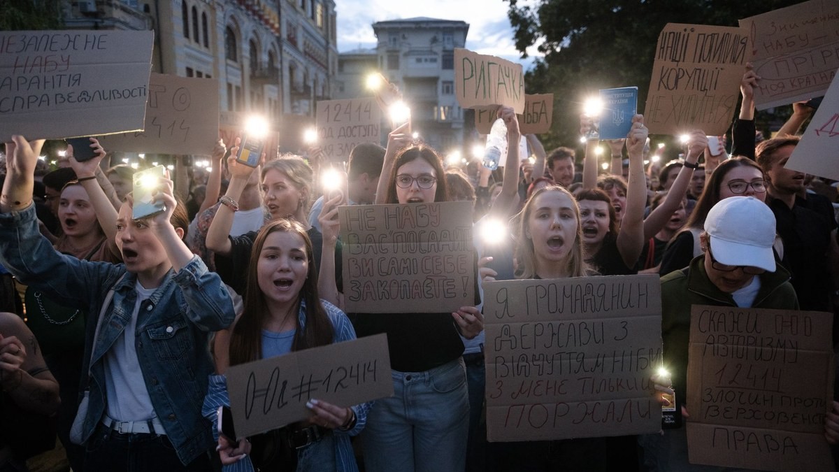 Protesters turn on phone flashlights and hold placards at a rally in Kyiv against a law restricting the independence of anti-corruption institutions, July 22, 2025. Photo: Getty Images via the Kyiv Independent