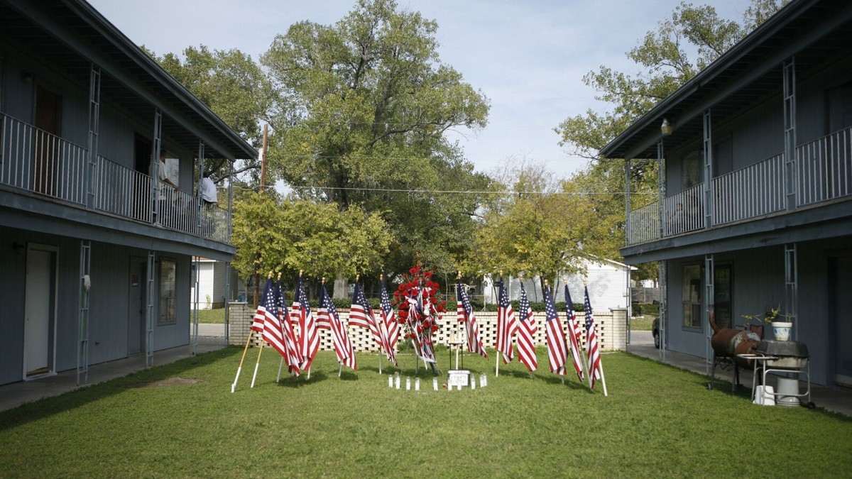 A memorial of American flags, flowers and candles outside the apartment complex where the 2009 Fort Hood shooter lived, pictured in November 2009. Photo: Getty Images via NPR