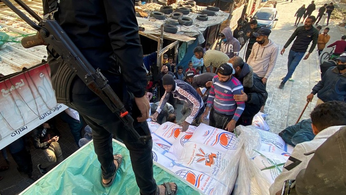 Palestinians unload sacks of wheat from a humanitarian aid truck outside a grocery store in Rafah, in the southern Gaza Strip. Photo: AP Photo