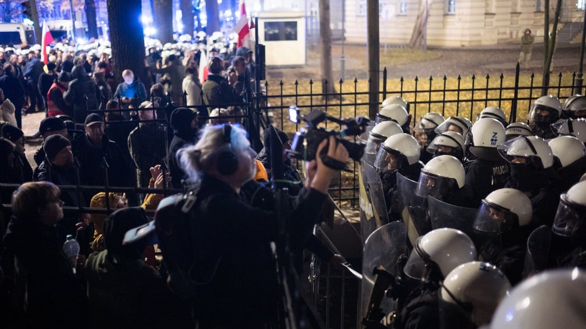 Police officers stand behind a fence as protesters gather outside Poland's Constitutional Tribunal in Warsaw. Photo: Agata Grzybowska/Anadolu/Getty Images