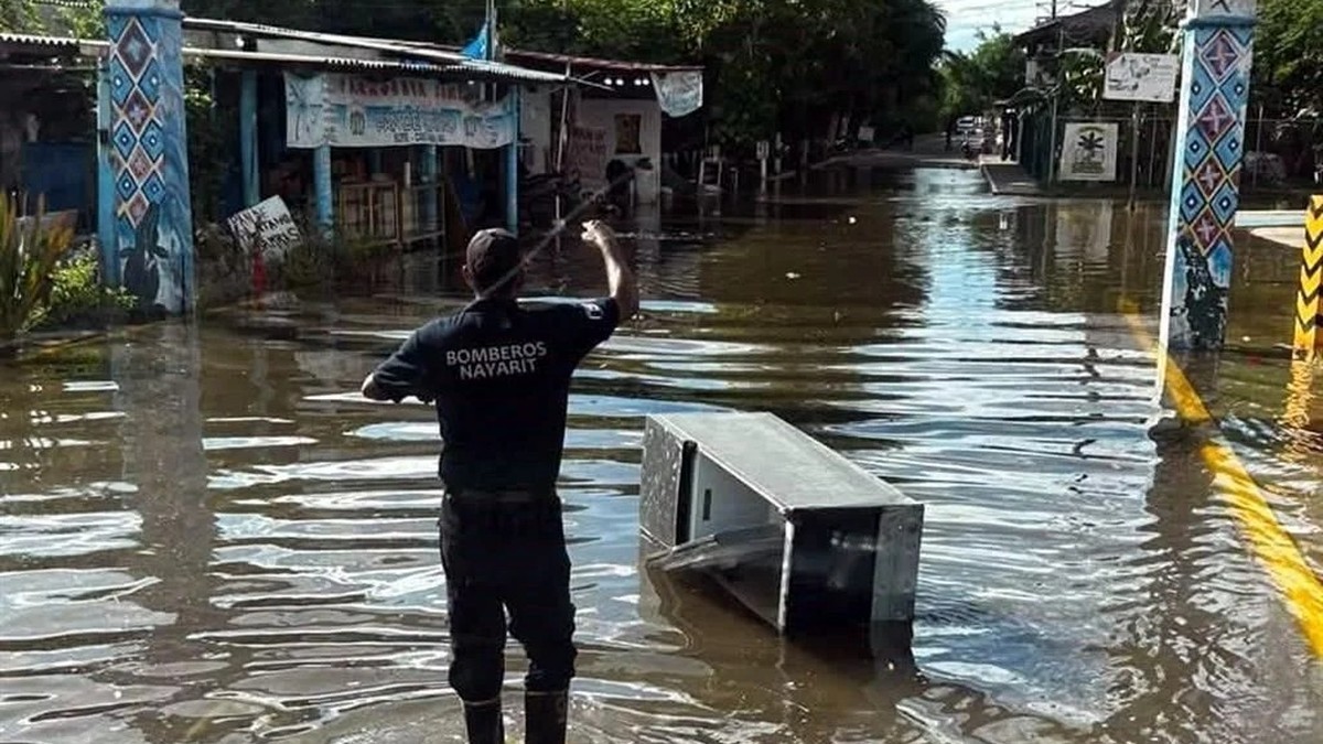 A rescuer wades through floodwater in Nayarit state, Mexico, as Hurricane Rachel drove high seas and heavy rain onto the Pacific coast. Photo: El Diario de Chihuahua / Agencia Reforma