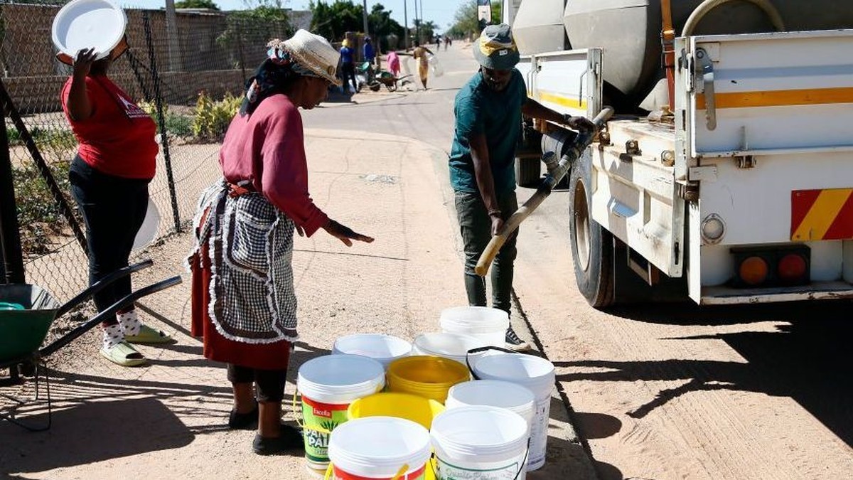 Residents fill containers with water from a tanker on a residential street in Tshwane, where unchlorinated water was linked to 408 cases of gastrointestinal illness. Photo: BBC
