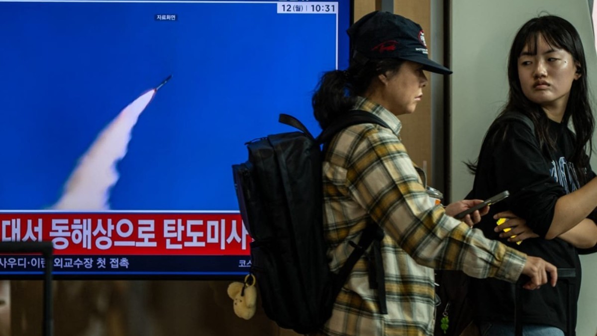 Two people in a Seoul public space watch a television news broadcast reporting a North Korean missile launch, with the screen showing file footage dated 12 October 2026. Photo: Philip Fong/AFP via CNA
