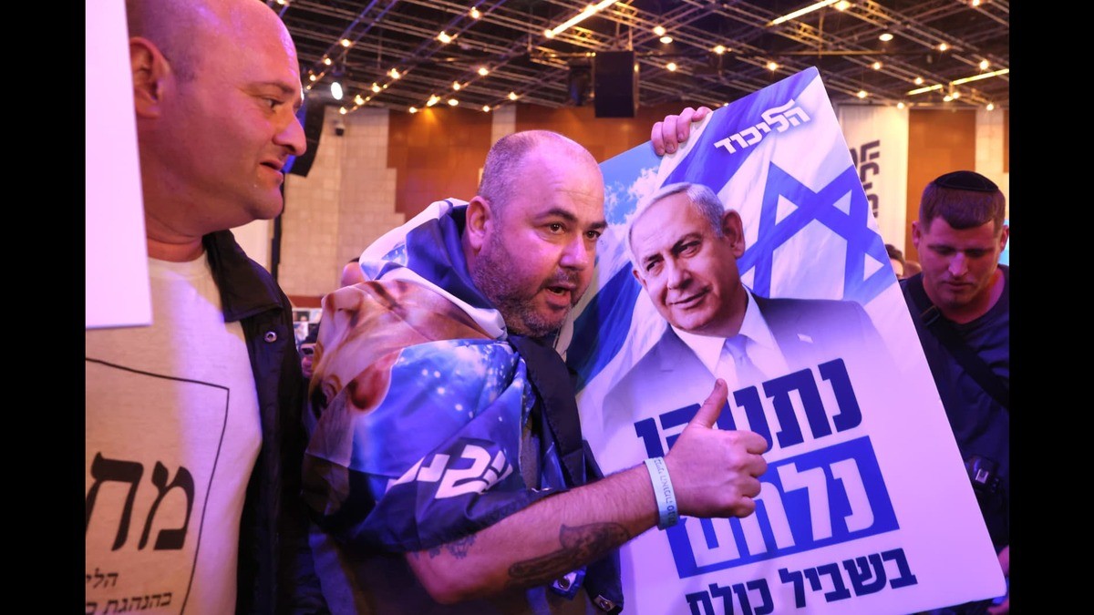 A supporter holds a Likud placard of Benjamin Netanyahu at the party's election headquarters in Jerusalem as the first exit polls are published, 27 October 2026. Photo: The Jerusalem Post
