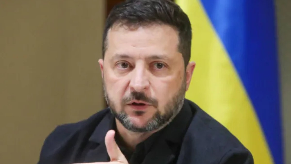 Ukraine's President Volodymyr Zelenskyy delivers a statement in front of the national flag