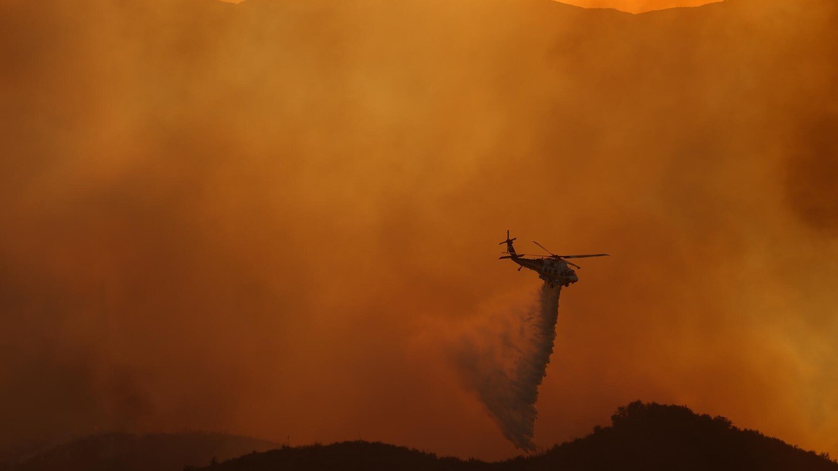 An L.A. County Fire Department helicopter makes a water drop on the Bryson Fire in Malibu, California. Photo: Eric Thayer/Los Angeles Times