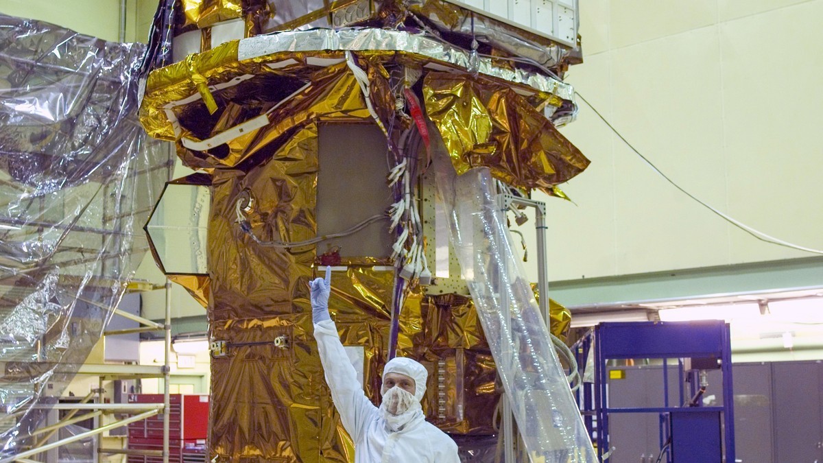 The completed Swift spacecraft in a clean room at NASA's Goddard Space Flight Center on Sept. 9, 2003, with Neil Gehrels, the mission's first principal investigator. Photo: NASA