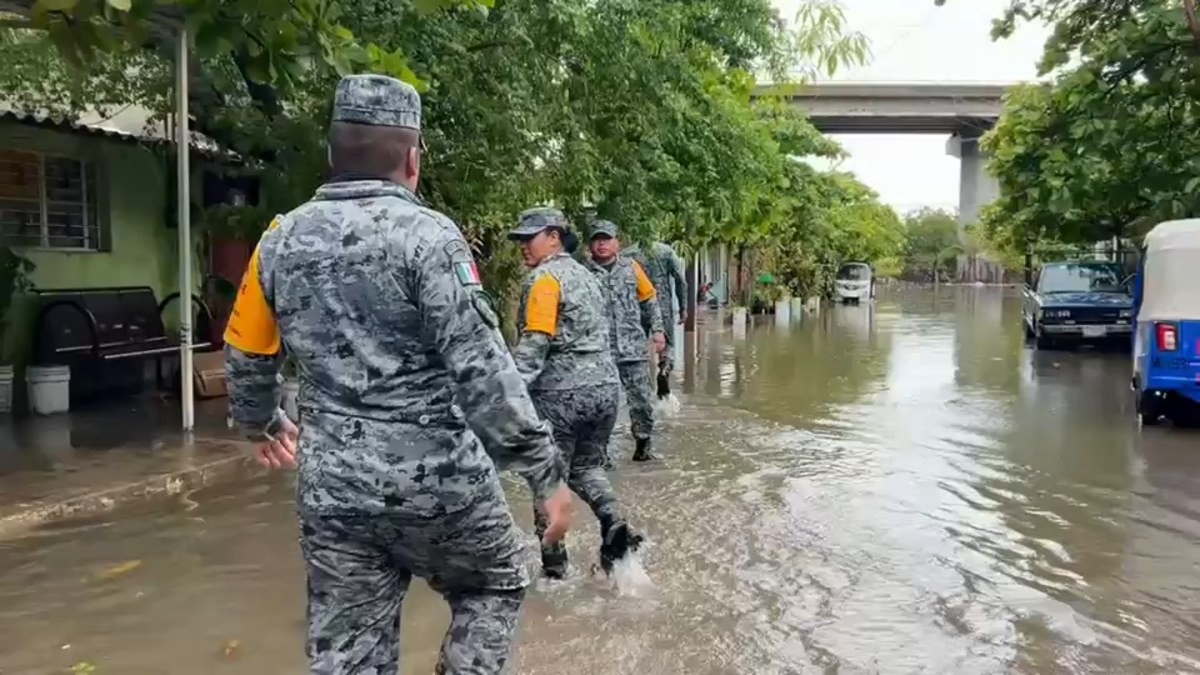 Uniformed personnel wade through a flooded street along Mexico's Pacific coast during Hurricane Simon. Photo: CNN