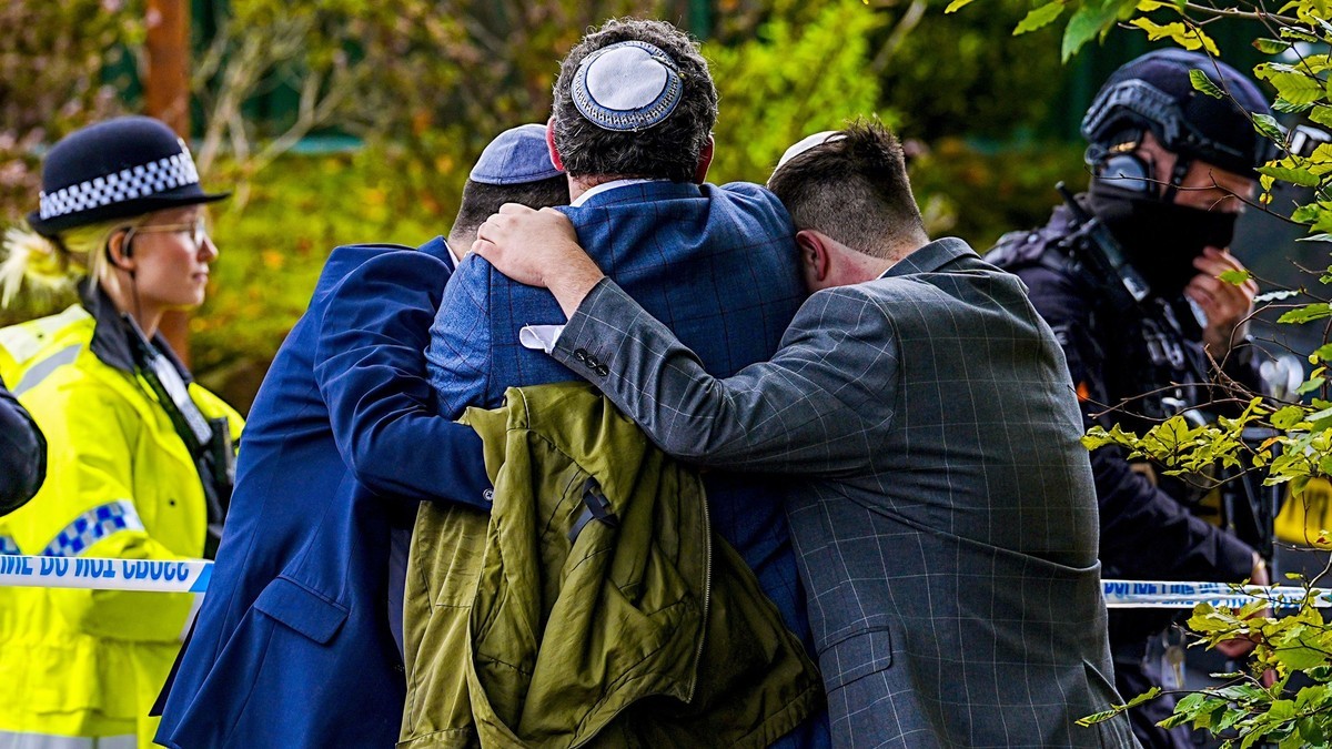 People embrace at a police cordon in Manchester. Photo: PA Media via BBC News