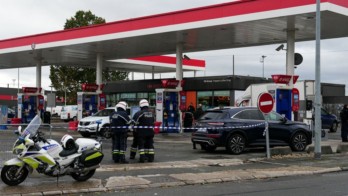 Police officers behind tape at a service station on rue Martin Luther King in Trappes after a gunman opened fire from his car on 23 October 2026. Credit: La Nouvelle Republique
